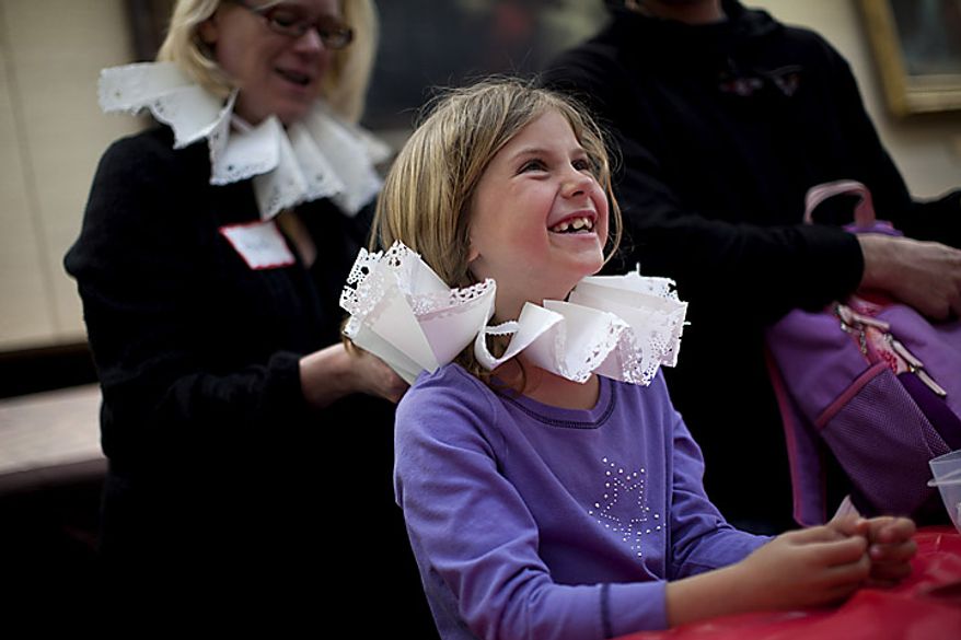 Lark Goodson,7, of the District, gets help from volunteer Heidi Keller as she puts on a Renaissance era "ruff" she made during an open house for Shakespeare's Birthday at the Folger Shakespeare Library, in Washington, D.C., Sunday, April 17, 2011. Ruffs were popular in the 1580s to 1590s. (Drew Angerer/The Washington Times)