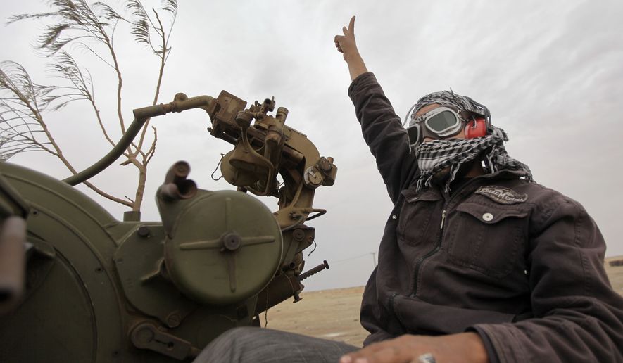 A Libyan rebel fighter manning an anti-aircraft gun flashes the victory sign Wednesday as his vehicle advances towards the front line, on the outskirts of Ajdabiya, Libya. Moammar Gadhafi&#39;s loyalists shelled the Nafusa mountain area and clashed with opposition forces in the besieged coastal city of Misrata on Wednesday, rebels said, as the Libyan leader also sought to quell resistance in the western part of the country that is largely under his control. (Associated Press)