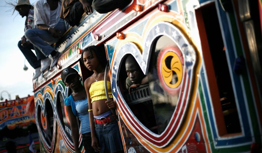 Haitians aboard a bus called a "tap tap" observe a Carnival parade in Port-au-Prince, Haiti, in February 2009. Along the side of one such bus is a painted shrine to T.I., an American rapper. (Associated Press)