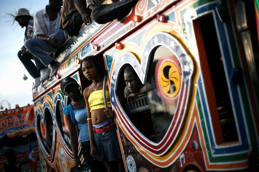 Haitians aboard a bus called a "tap tap" observe a Carnival parade in Port-au-Prince, Haiti, in February 2009. Along the side of one such bus is a painted shrine to T.I., an American rapper. (Associated Press)