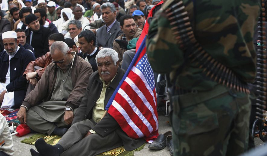 A Libyan man carries a U.S. flag while attending Muslim weekly Friday prayers in Benghazi, Libya, Friday, April 22, 2011. U.S. Sen. John McCain praised Libya's rebels as his "heroes" in a visit to their de facto capital Friday, a day after the United States started flying armed drones to bolster NATO firepower and try to break a battlefield stalemate with Moammar Gadhafi's forces. (AP Photo/Nasser Nasser)