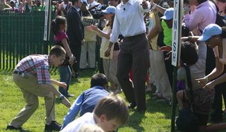 President Obama cheers on a group of children rolling their eggs toward the finish line at the annual White House Easter Egg Roll on April 25, 2011, on the South Lawn of the White House. (Associated Press)