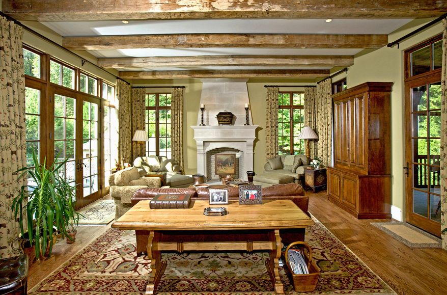 The step-down family room has a limestone fireplace. The room opens to a terrace on one side and a screened porch on the other.