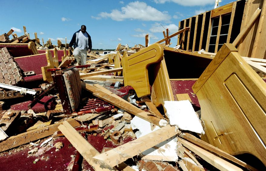 Associated Press photographs
Ennis McLin walks Thursday through the remains of Lakeview United Methodist Church, destroyed the day before by a tornado near Tanner, Ala.