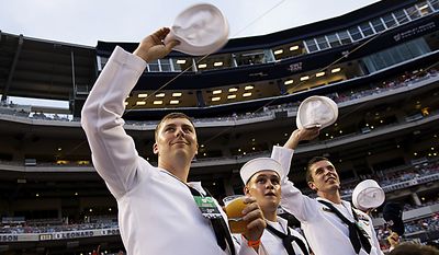 U.S. Navy Petty Officer Matt Cobb (center) and seamen Juan Sosa (center) and Oleksandr Chulovsky acknowledge the crowd&#39;s standing ovation at Nationals Park for military service men and women during Military Appreciation Night at the park in Washington, D.C., Monday, May 2, 2011. (Drew Angerer/The Washington Times)