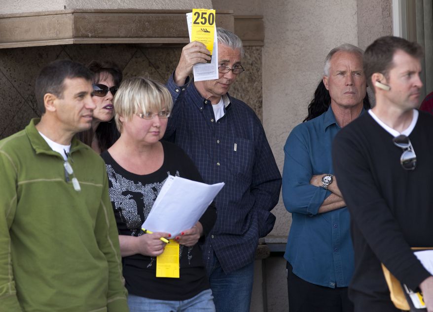**FILE** A home buyer who declined to be identified makes a bid on a house during an April 14 foreclosure auction in Las Vegas. (Associated Press)