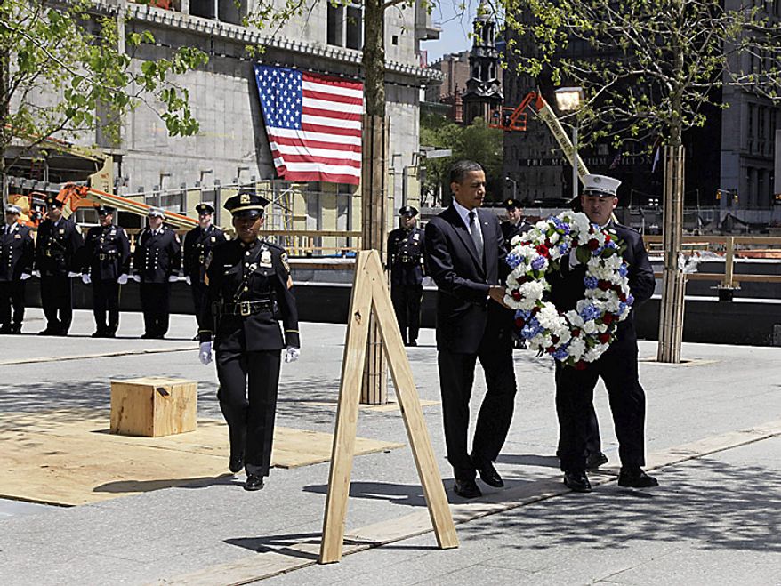 President Barack Obama and a New York City Fire Dept. lieutenant carry a wreath to be placed at the World Trade Center site, in New York, Thursday, May 5, 2011. (AP Photo/Richard Drew)