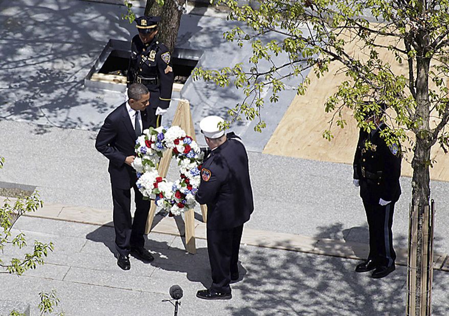 President Barack Obama and a New York City Fire Dept. lieutenant carry a wreath to be placed at the World Trade Center site, in New York, Thursday, May 5, 2011. (AP Photo/Seth Wenig)