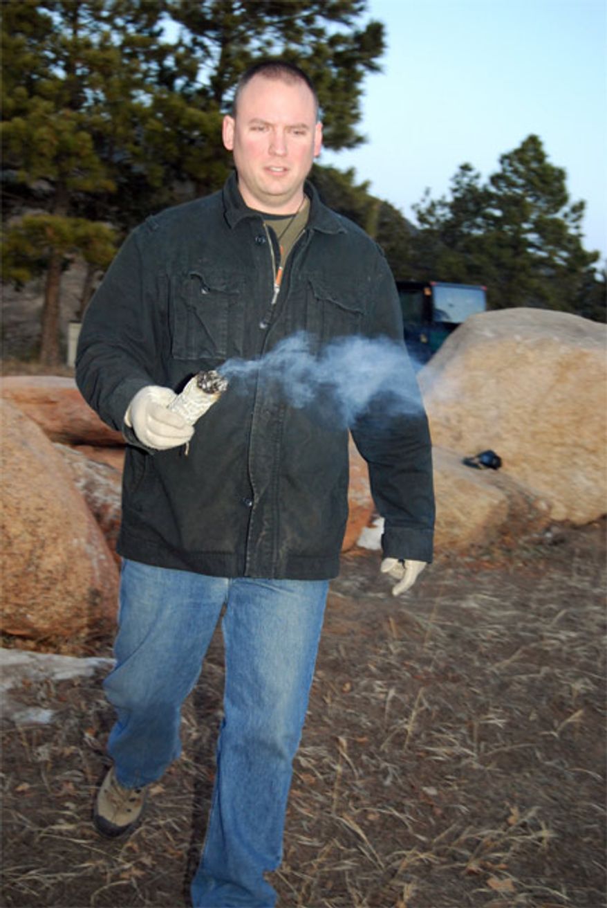 ** FILE ** Tech. Sgt. Brandon Longcrier uses white sage to consecrate a pagan worship area on the hill overlooking the Cadet Chapel and the Visitor Center at the Air Force Academy in Colorado Springs, Colo., just after sunrise on the winter solstice, Dec. 21, 2009. Sgt. Longcrier is the pagan lay leader at the academy. (U.S. Air Force photo/Staff Sgt. Don Branum)