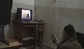 ** FILE ** In this undated image from video seized from the walled compound of al Qaeda leader Osama bin Laden in Abbottabad, Pakistan, and released on Saturday, May 7, 2011, by the U.S. Department of Defense, a man whom the American government identified as Osama bin Laden watches television with an image of President Obama on the screen. Bin Laden was killed by U.S. troops. (AP Photo/U.S. Department of Defense)