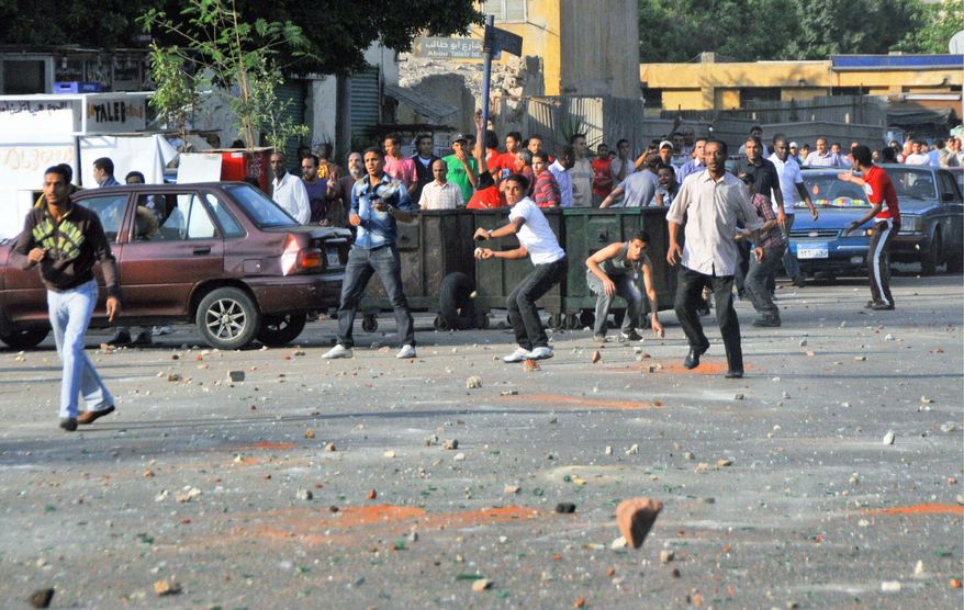 ASSOCIATED PRESS
Crowds rampage through the streets of Cairo in renewed sectarian violence, as groups of Christians and Muslims throw rocks at each other near the city center. The clashes Sunday came hours after ultraconservative Muslim mobs set fire overnight to a church and a Christian-owned apartment building in a frenzy of violence that killed 12 people and injured more than 200.