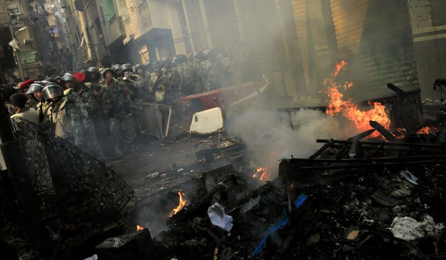 Egyptian army forces guard burned furniture from a building belonging to Christians that was set afire during clashes between Muslims and Christians in the Imbaba neighborhood of Cairo on Sunday, May 8, 2011. (AP Photo/Khalil Hamra)