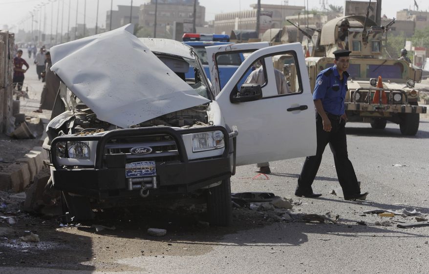 Iraqi security forces Monday inspect the scene of a roadside bomb attack in Baghdad targeting a police patrol, killing and wounding a few civilians, police said. (Associated Press)