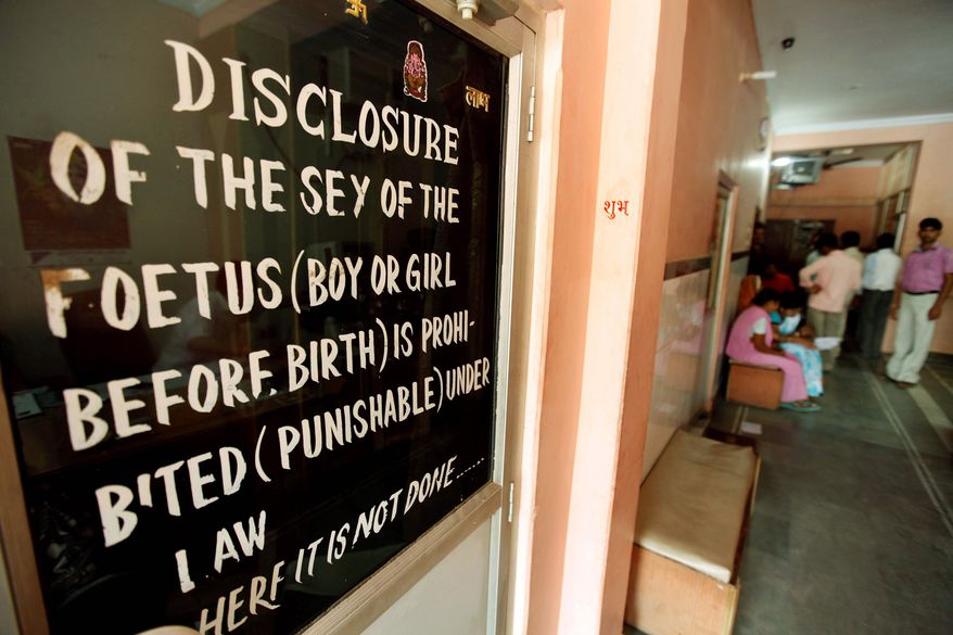 **FILE** A sign outside a clinic in Madhya Pradesh warns that revealing the sex of an unborn child is illegal. The law, passed in 1994, is an attempt to cut down on the incidence of sex-selective abortions. (Associated Press)