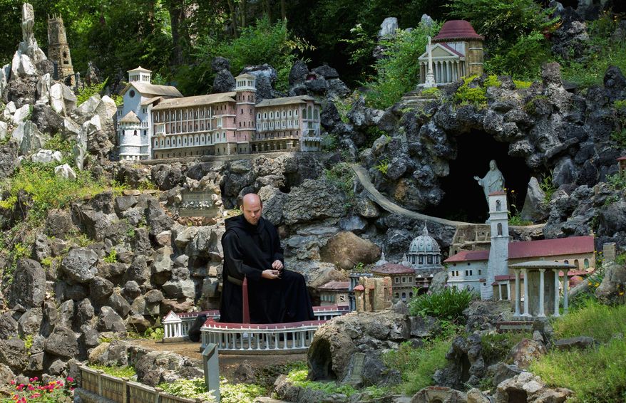 Brother Martin Weidner cleans leaves from the artwork at the Ave Maria Grotto in Cullman, Ala., that was spared the wrath of killer tornadoes. The four-acre park filled with tiny replicas of the world's religious venues has become a place to seek solace. (Associated Press)