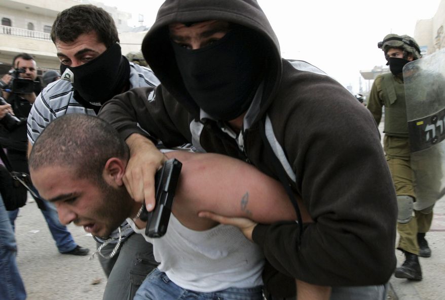 A plainclothes Israeli police officer detains a Palestinian protester at the Qalandiya checkpoint between Ramallah and Jerusalem. "We hope calm and quiet will quickly return, but nobody should be mistaken. We are determined to defend our borders and sovereignty," said Israeli Prime Minister Benjamin Netanyahu.