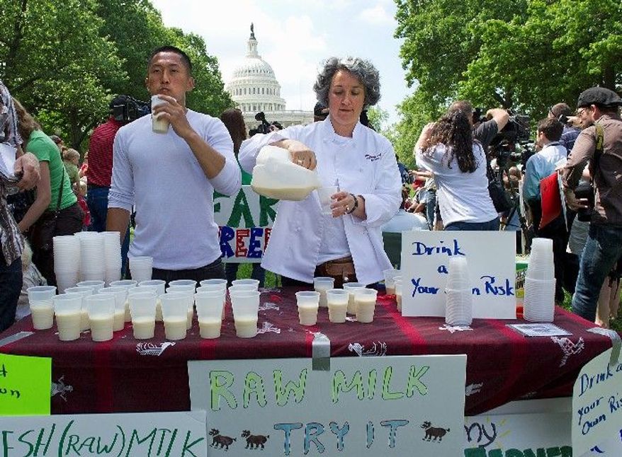 University of Maryland student Jake Lee (left) and Monica Corrado, the owner of Simply Being Well, serve fresh raw milk at a rally held by Grassfed on the Hill in Washington on May 16, 2011. The rally was held to protest the sting operation conducted by the FDA against Pennsylvania dairy farmer Dan Allgyer. (Barbara L. Salisbury/The Washington Times)