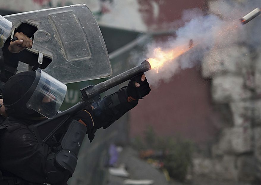 An Israeli police officer fires tear gas at Palestinian protesters, not seen, during clashes in the east Jerusalem neighborhood of Issawiyeh, Sunday, May 15, 2011. Israeli troops clashed with Arab protesters along three hostile borders on Sunday, leaving as many as 12 people dead and dozens wounded (...)