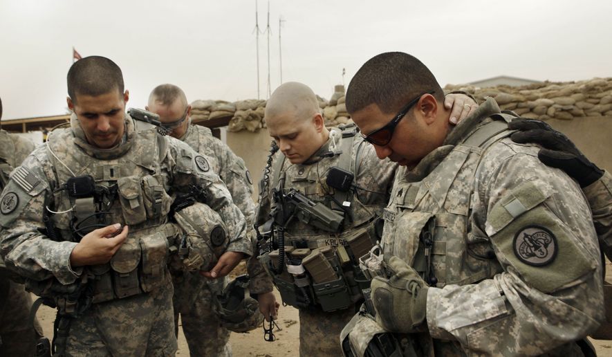 ** FILE ** U.S. Army Lt. Daniel McCord (left), Staff Sgt. Marc Krugh (center) and Sgt. Christopher Torrentes of the 3rd Armored Cavalry Regiment pray before heading out on a patrol at Contingency Operating Site Kalsu, south of Baghdad, Iraq, on Tuesday, Jan. 25, 2011. (AP Photo/Maya Alleruzzo, File)