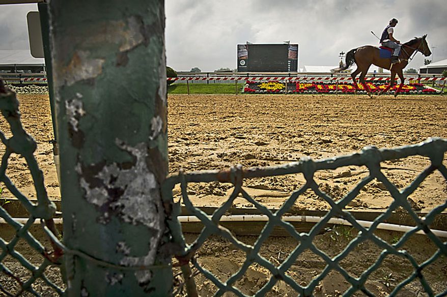 Rust , chipped paint and a broken fence are seen as a rider makes his way along the track five days before the 136th running of the Preakness Stakes, as the grounds at the Pimlico Race Course are still in need of repair in Baltimore, Md., Monday, May 16, 2011. (Rod Lamkey Jr./The Washington Times)