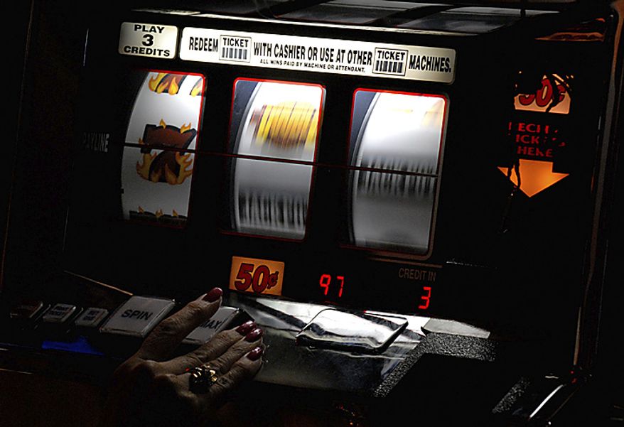 A patron tries her luck at a slot machine. ( Peter Lockley / The Washington TImes )