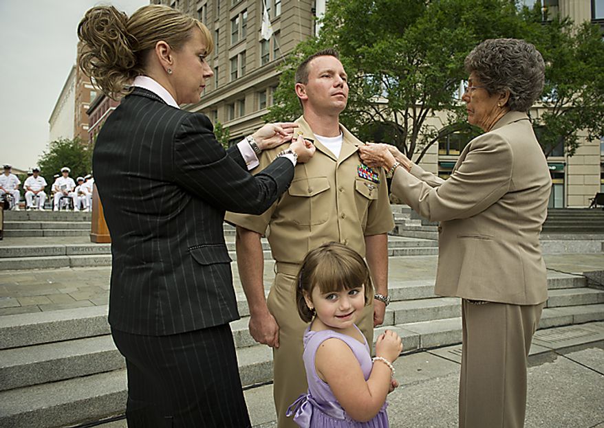 USN AWF1 (NAC/AW) James L. Henson (center) receives his pins from his wife Jeniece (left) and mother Robin Willson (right) while his daughter Avery Henson,4, (center) looks on during the Sailor of the Year 2010 ceremony at the U.S. Navy Memorial in Washington, D.C., Thursday, May 19, 2011. The Sailor of the Year program began in 1972 to recognize the outstanding Sailors of the Atlantic and Pacific Fleets. (Rod Lamkey Jr./The Washington Times)