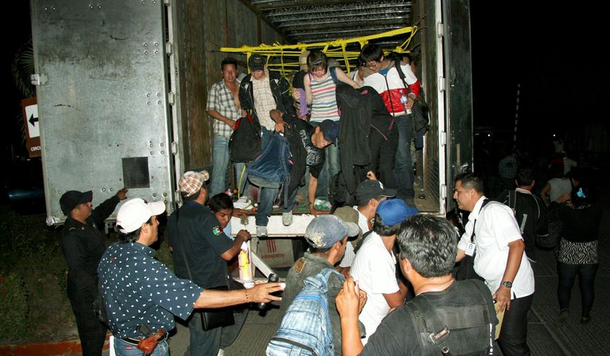 ** FILE ** Migrants from Latin America and Asia leave a truck that was heading to the United States after being detected by X-ray equipment at a checkpoint. Police in Mexico&#39;s southern Chiapas state found more than 500 migrants May 17 inside two trailer trucks. (Associated Press)