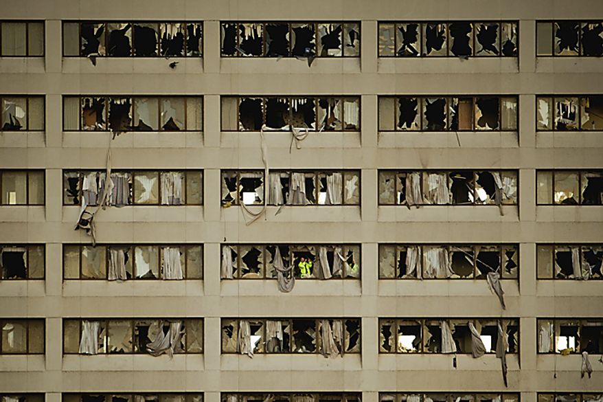 Rescue workers in lime-green jackets search for bodies and survivors inside St. John's Regional Medical Center in Joplin, Mo., on Monday, May 23, 2011. The hospital was damaged by a tornado that destroyed nearly 30 percent of the city on Sunday afternoon. (AP Photo/Tulsa World, Adam Wisneski)