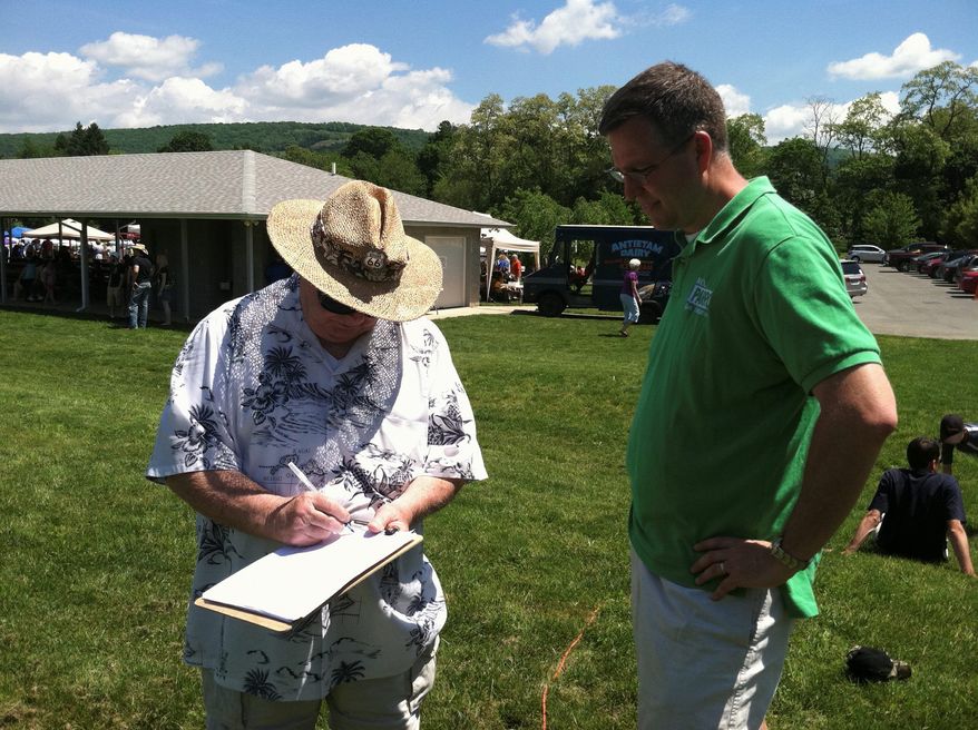 Maryland Delegate Neil C. Parrott, Washington County Republican, watches last May in Smithsburg, Md., as Paul Spangler of Emmitsburg, Md., signs a petition against the recently passed Dream Act. (David Hill/The Washington Times)