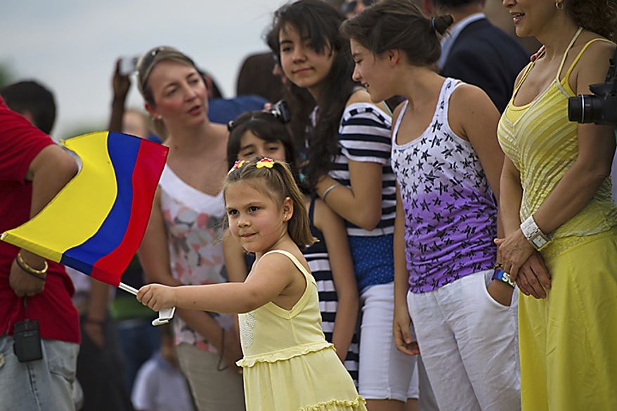 Carissa Simon, 5, of Annadale, waves the Colombian flag as the ARC "Gloria" prepares to dock on the waterfront in Alexandria, Va., on May 24, 2011. The ARC "Gloria" is Colombia's flagship and the training ship of the Colombian Navy. (Drew Angerer/The Washington Times)