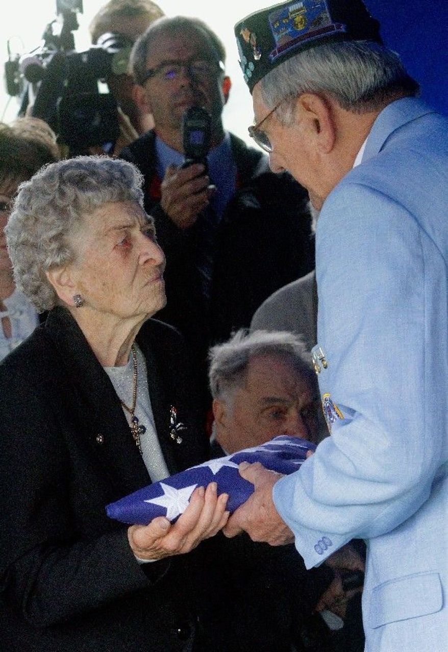 Frances Meyers, 88, receives the flag that covered her brother Artie Hodapp's casket from Korean War veteran Dwight Allmon during services in Freeport, Ill., on Wednesday. (Associated Press)