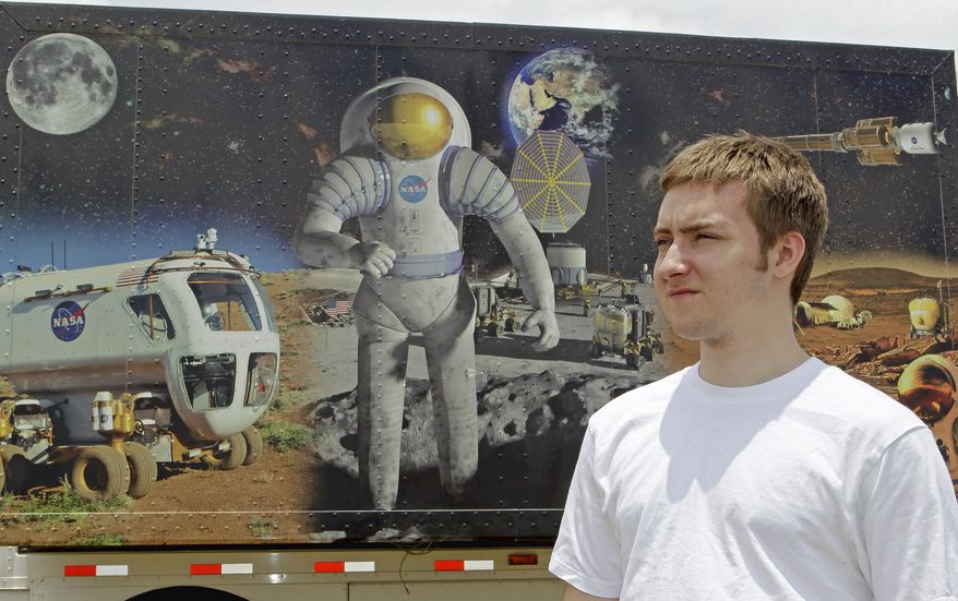 John Burnham, one of two dozen recipients of a unique scholarship, walks past a space mural at the Kennedy Space Center Visitor Complex in Cape Canaveral, Fla. John is being paid not to go to college and instead will work on an ambitious science project involving building mines on asteroids. (Associated Press)