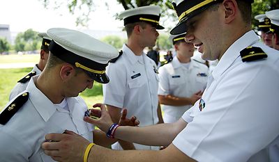 Both student cadets at the Massachusetts Maritime Academy in Cape Cod, Doug Proctor, right, adjusts the nameplate on the uniform of Anthony Venterosa, left, before the National Memorial Day Parade, near the National Mall in Washington, D.C., Monday, May 30, 2011. The group from the school had been here since Friday and spent the weekend taking in the monuments and museums. (Drew Angerer/The Washington Times)