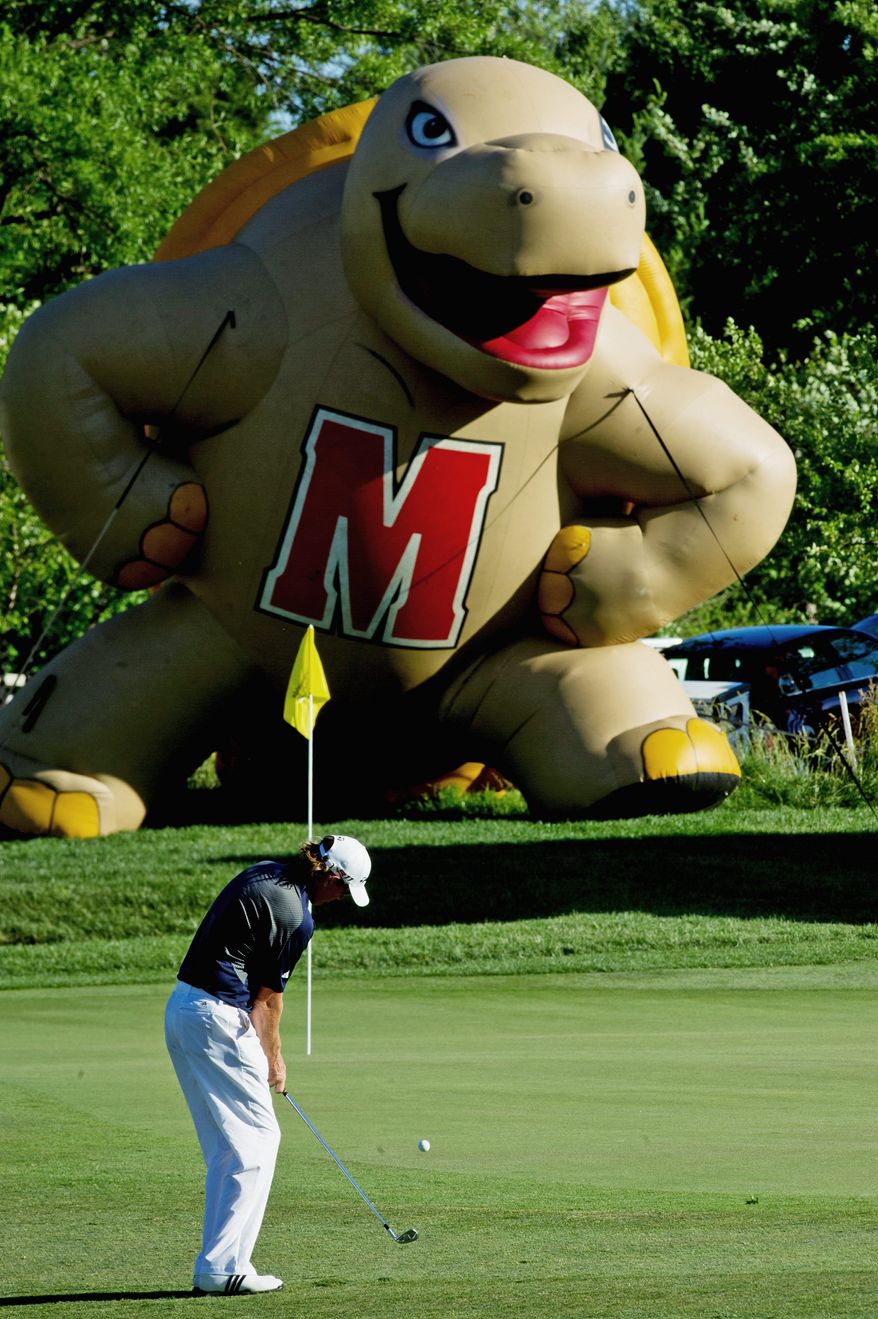 DREW ANGERER/THE WASHINGTON TIMES
With an inflatable University of Maryland Terrapin looming over the green, Greg Owen makes a chip shot on the 18th hole during the first round of the Prince George's County Open. The Nationwide Tour event is being held at the University of Maryland Golf Course in College Park.