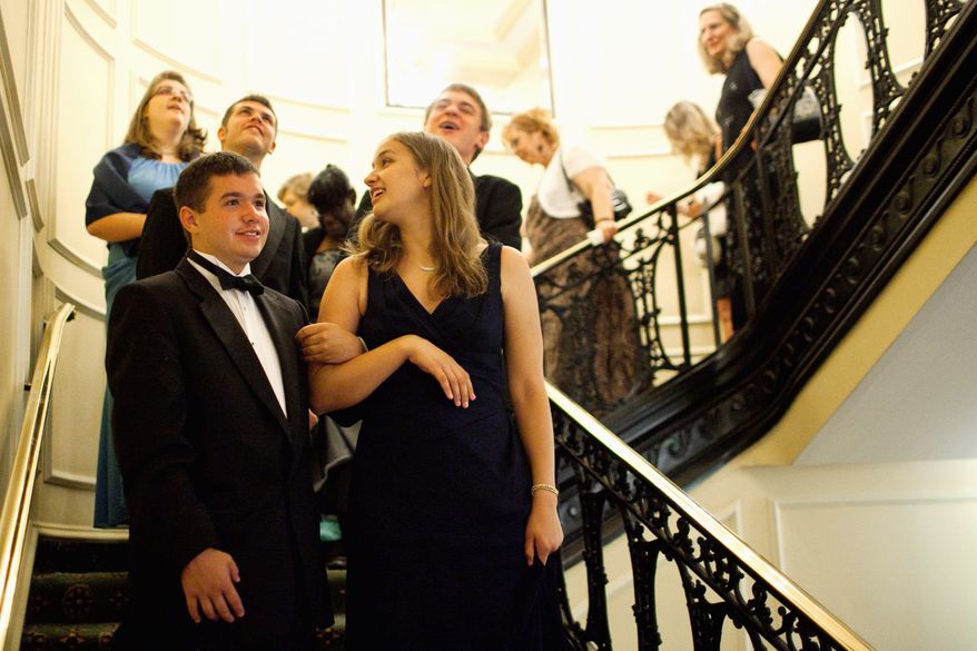 Walking arm in arm, Ryan O'Meara and Lindsey Brandt go down the stairs to the ballroom. "All of the kids talk about it and enjoy this event," said Janet Rogers, the mother of one attendee. The Rogers family paid $1,500 to sponsor a table. (Drew Angerer/The Washington Times)
