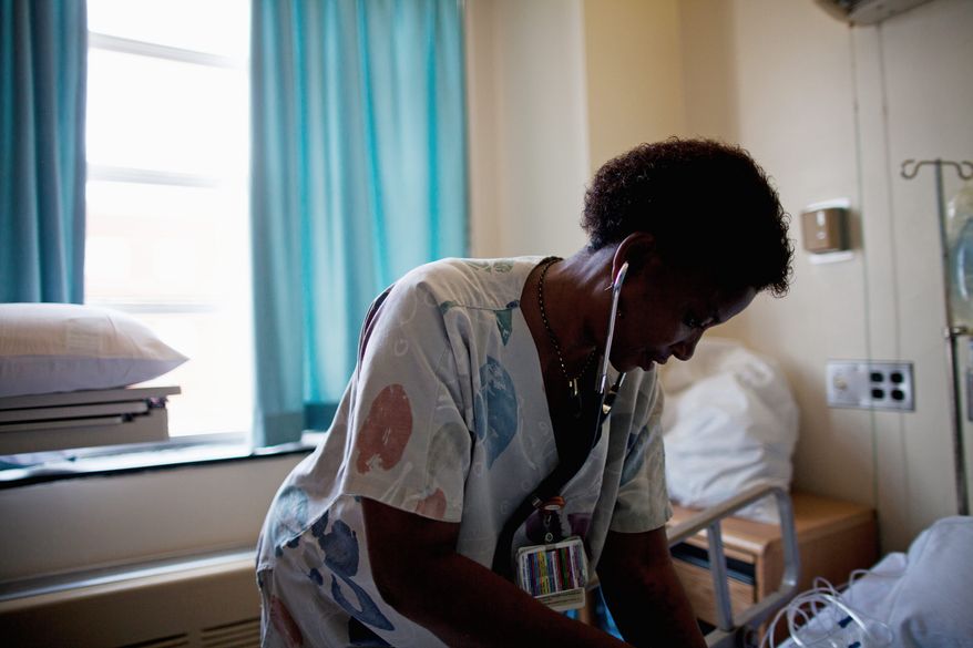 PHOTOGRAPHS BY PRATIK SHAH/THE WASHINGTON TIMES
Registered nurse Kudi Asafa checks a patient Monday at the Washington Hospital Center in Northwest. Ms. Asafa, a clinical specialist living in the District, works in the Cardiac Services Unit. The economic downturn of the past few years has only temporarily eased the nation's shortage of nurses.