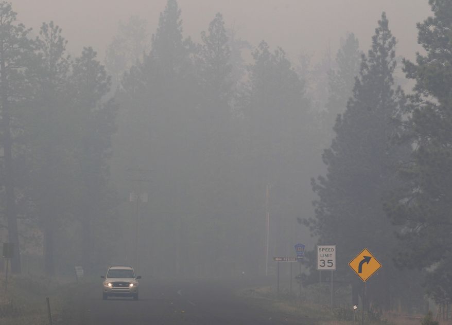 An SUV drives through heavy smoke in Greer, Ariz., on Sunday, June 5, 2011. Crews used controlled backfires early Sunday to blunt the advance of a major wildfire near mountain communities in eastern Arizona, a blaze termed "absolutely frightening" by the state's governor. (AP Photo/Jae C. Hong)