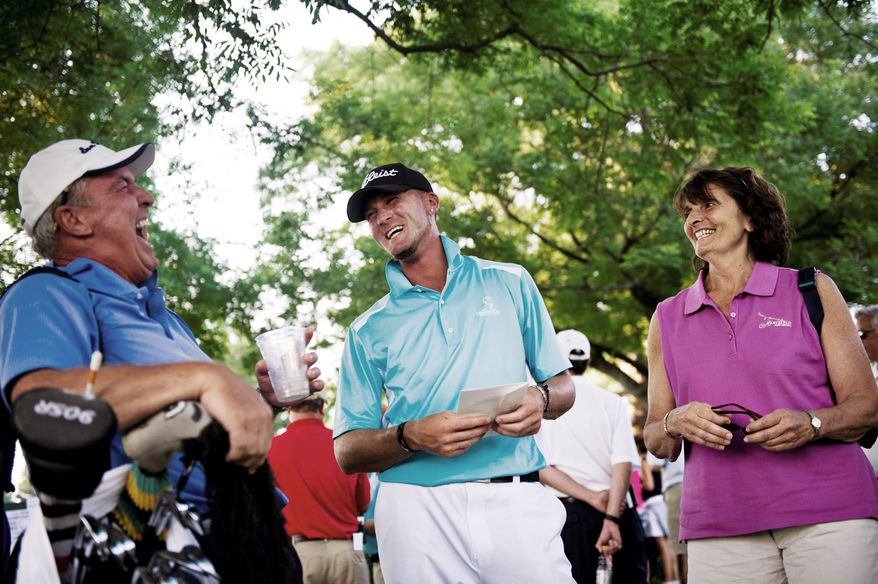 Michael Tobiason Jr. (center) of Wilmington, Del., shares a laugh with his caddy and what he calls his "adopted father," Gerry Thornton, and his mother, Joan, at the U.S. Open qualifying tournament at Woodmont Country Club in Rockville, Md., on Monday, June 6, 2011. Tobiason was one of the 10 qualifiers and shot 6-under on the day. (Drew Angerer/The Washington Times)