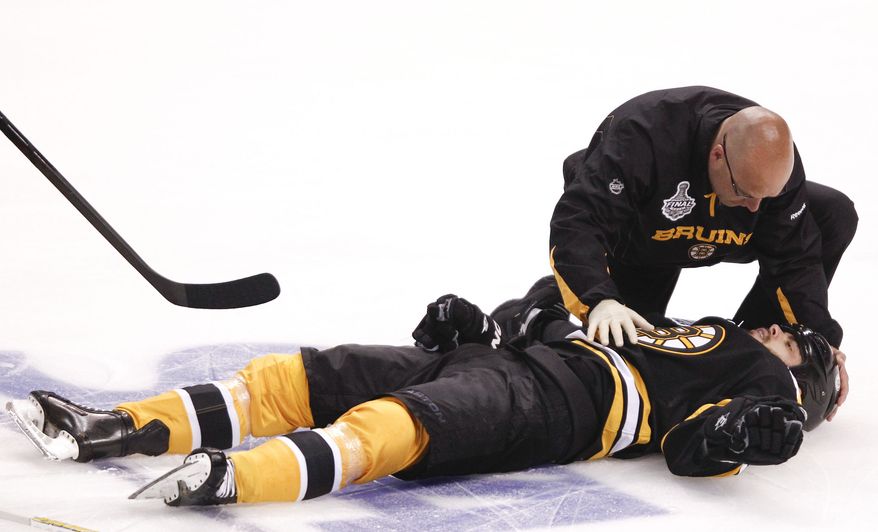 Boston Bruins right wing Nathan Horton (18) is tended to by a trainer after a blind-side hit by Vancouver Canucks' Aaron Rome in the first period during Game 3 of the NHL hockey Stanley Cup Finals, Monday, June 6, 2011, in Boston. Horton was carried out on a stretcher and sustained a concussion which will sideline him for the rest of the series. Rome was called for a 5 minute interference major and a game misconduct, and was suspended for the rest of the series. (AP Photo/Winslow Townson)