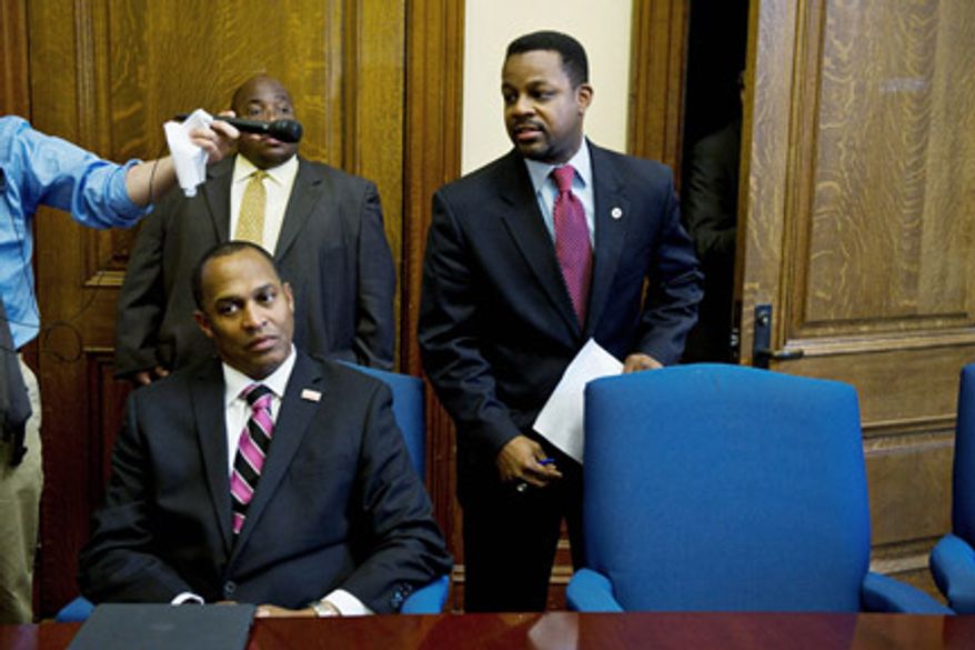 Council Chairman Kwame R. Brown (right) announces a closed-door session of council at the John A. Wilson Building on Tuesday as council member Harry Thomas Jr. sits beside him in a conference room. Mr. Brown later said that an announcement will be made Wednesday on whether Mr. Thomas faces sanctions in light a misuse of funds allegation.(DREW ANGERER/THE WASHINGTON TIMES)