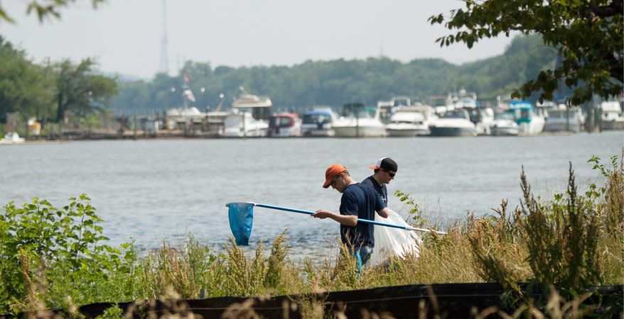 Volunteer Dave Southers, 38, from Washington, and Oceana member Kevin Connor, 29, from Arlington, look for trash along the Anacostia River during the river cleanup at Anacostia Park on Wednesday. (Pratik Shah/The Washington Times)
