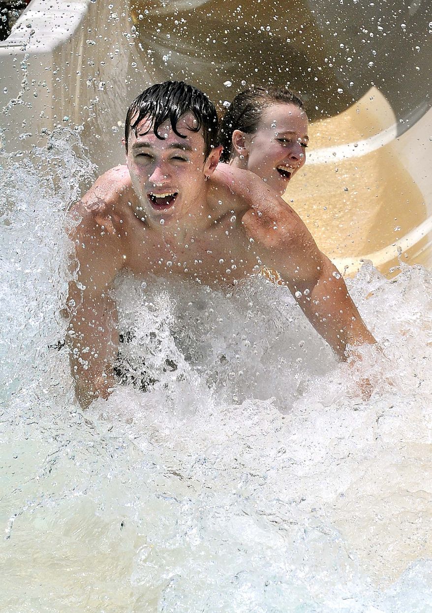 Cody Wickline and Harley Bahr, both from Beckley, W.Va., slide down the water slide on June 7, 2011, at New River Park in Beckley. (Associated Press/The Register-Herald)