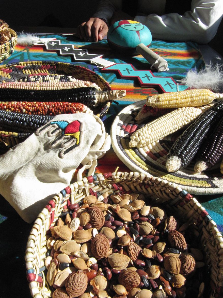 An assortment of corn and seeds, as well as a lightning rod and rattle, is displayed for visitors to examine. (Associated Press)
