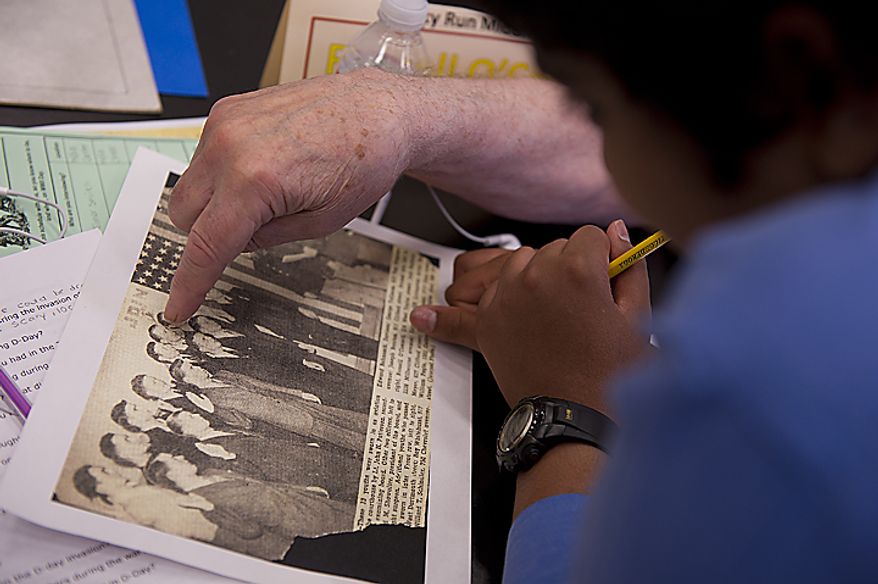 A Rocky Run Middle School student looks on as World War II vet Russell O'Connell of Annandale, Va., points out different war buddies in an old photograph during the Chantilly, Va. school's annual World War II Day, called "The Latest Generation Meets the Greatest Generation," on Thursday, June 9, 2011. The day included small-group interviews with WWII vets as well as panel discussions and World War II-inspired entertainment provided by the students. More than 100 vets participated. (Barbara L. Salisbury/The Washington Times)