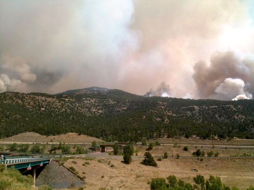 ASSOCIATED PRESS
Smoke rises from the Track Fire burning near Raton, N.M., on Monday. The fire has charred about 2,700 acres and has forced the closure of Interstate 25 near the New Mexico-Colorado border.