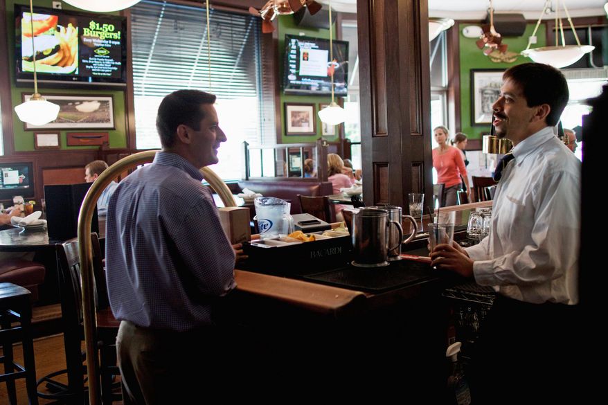 Dan Pollock, an operating partner at BlackFinn American Saloon in Bethesda, speaks with a bartender at his restaurant on Monday. The eatery, about five miles from Congressional Country Club, expects to be very busy this week with the U.S. Open being played on the Blue Course. (Pratik Shah/The Washington Times)