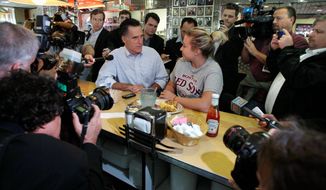 ASSOCIATED PRESS
Former Massachusetts Gov. Mitt Romney, a Republican presidential hopeful, talks with a woman eating breakfast at the counter of a diner as they are surrounded by photographers and reporters during a campaign stop in Derry, N.H., on Tuesday. Many of the GOP candidates took advantage of campaigning in the state after Monday evening&#x27;s Republican presidential debate.