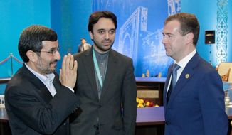 Iranian President Mahmoud Ahmadinejad (left) and Russian President Dmitry Medvedev (right) meet on the sidelines of the summit of the Shanghai Cooperation Organization in Kazakhstan&#39;s capital, Astana, on Wednesday, June 15, 2011. The man in the middle was not identified. (AP Photo/RIA Novosti, Mikhail Klimentyev, Presidential Press Service)