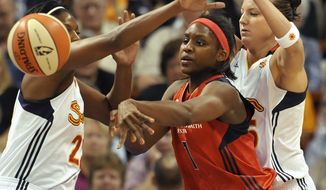 Washington Mystics&#39; Crystal Langhorne, center passes while guarded by Connecticut Sun&#39;s DeMya Walker, left, and Kelsey Griffin, right, during the first half of a WNBA basketball game in Uncasville, Conn., on Saturday, June 4, 2011. (AP Photo/Jessica Hill)