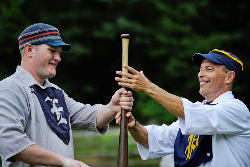 Elkton Eclipse outfielder Glyn "Hammer" Richards (below, left) of Mount Ephraim, N.J., and J.D. Almond do the "bat toss" before the start of the game. The winner of the hand-over-hand action chooses if his team will field or hit first. Players of vintage baseball don't wear gloves in the field and batters don't wear helmets.